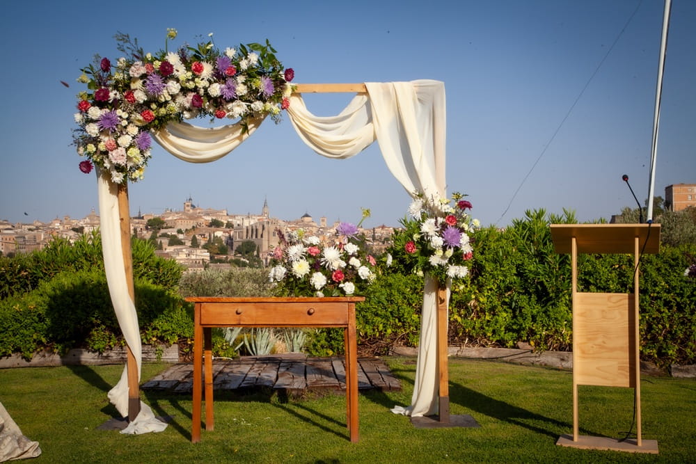 Spanish wedding ceremony setup with bridal arch and views of Toledo in the background